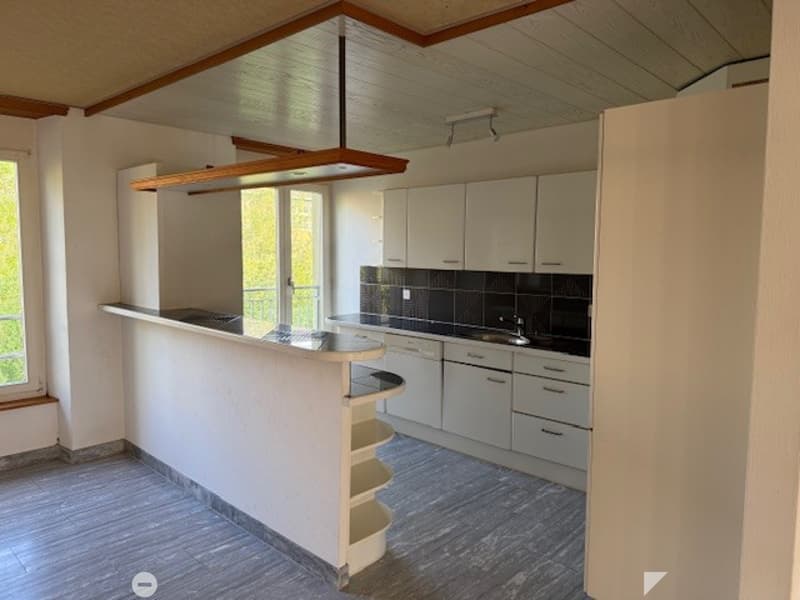 kitchen with island, white cabinets, black tiled backsplash, open balcony