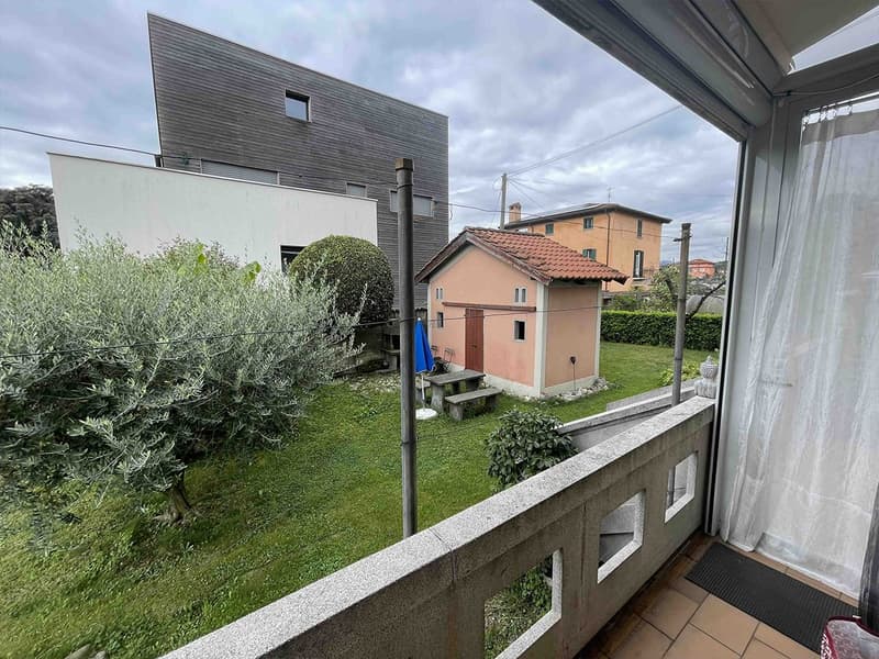 Balcony with tiled floor and view of backyard with house and greenery