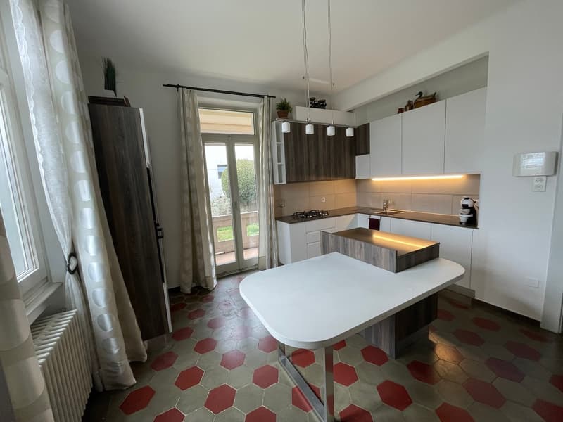 modern kitchen with white countertop, hexagon tiles, white cabinets, pendant lighting, French door balcony, sliding door
