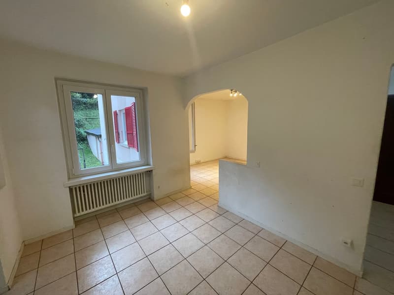 empty room, white walls, tiled floor, window with red shutters, white radiator