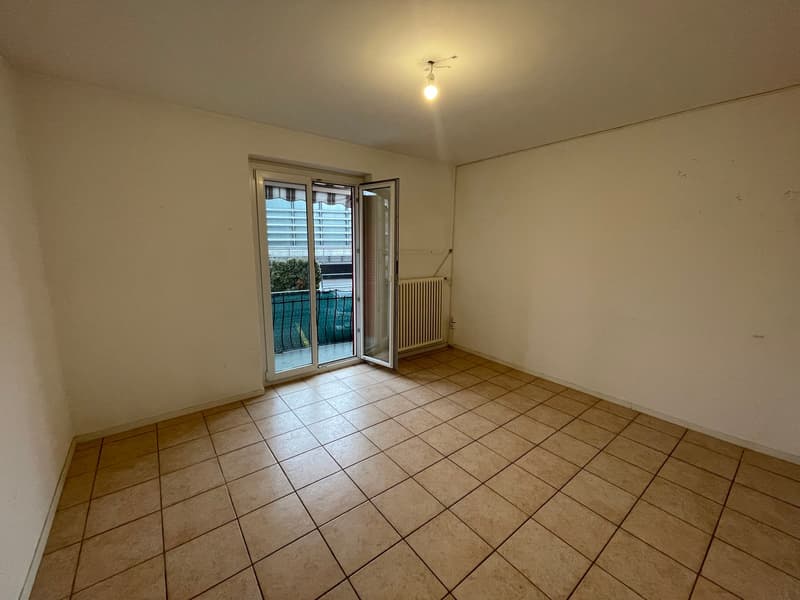empty room, white walls, tiled floor, sliding door to balcony, radiator