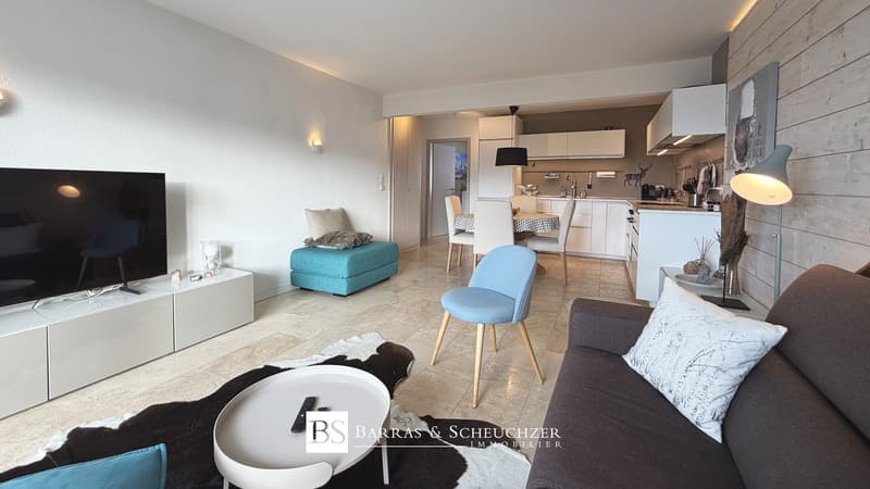 Pièce principale / a living room and kitchen in a modern apartment with white furniture