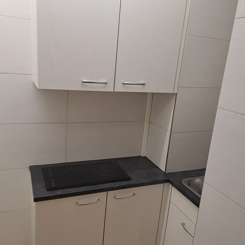 white kitchen with black countertop, dishwasher, washing machine, gas stove, cabinets, and sink