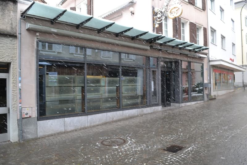 Facade of building with a canopy, glass windows, and signage.