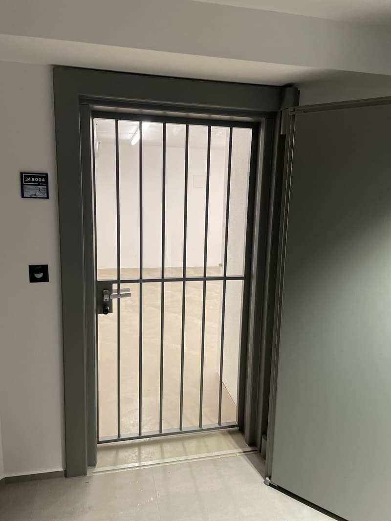 Entrance to building with a metal security gate and a digital display panel