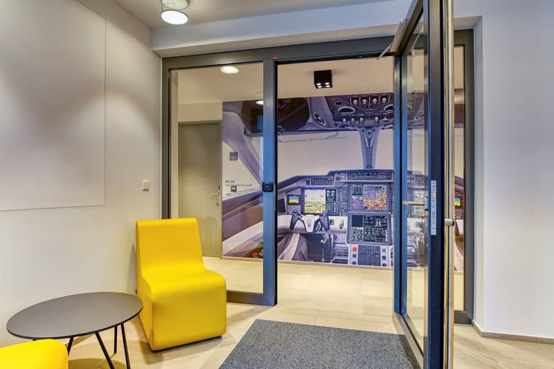 yellow chairs, round table, large picture of cockpit, tile floor