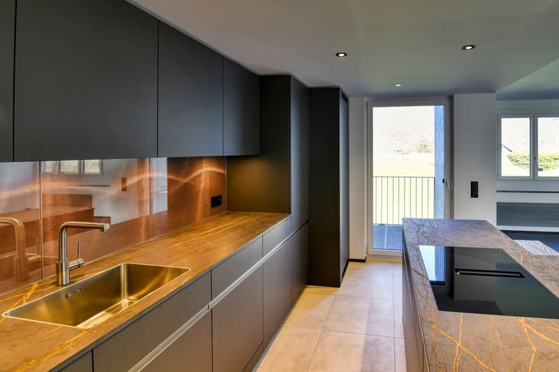 modern kitchen with wooden countertops, stainless steel sink, black cabinets, glass door, balcony