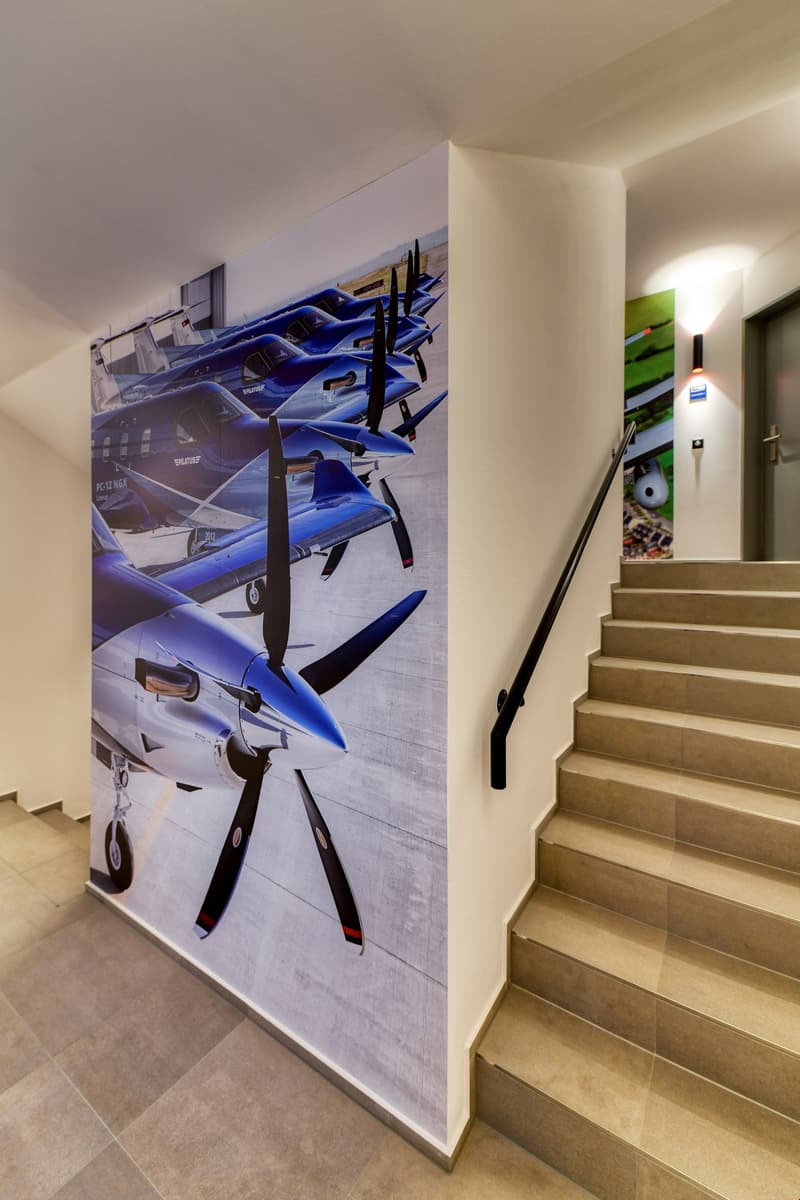 tiled floor, airplane mural, black handrail, stairs