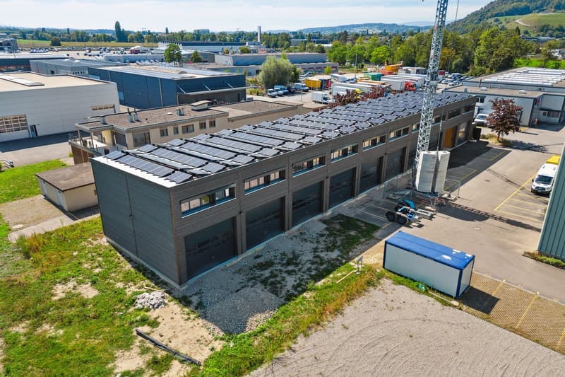 Industrial building with large garage doors and solar panels on the roof