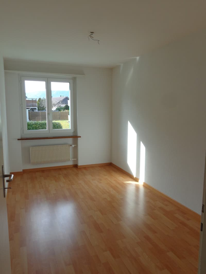 empty room, wooden floor, white walls, large window, heater, doors