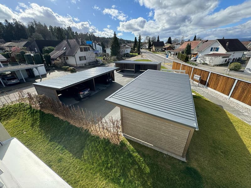 2 garages in front of house, cars inside, 2 other parked cars