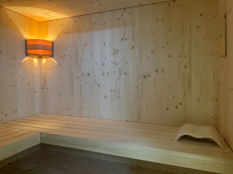 Wooden walls and benches, wooden floor, single wall light fixture