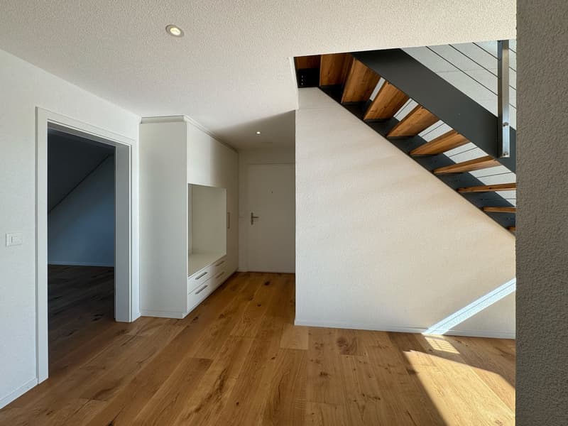 empty room, wooden floor, white walls, stairs, cabinets, and door