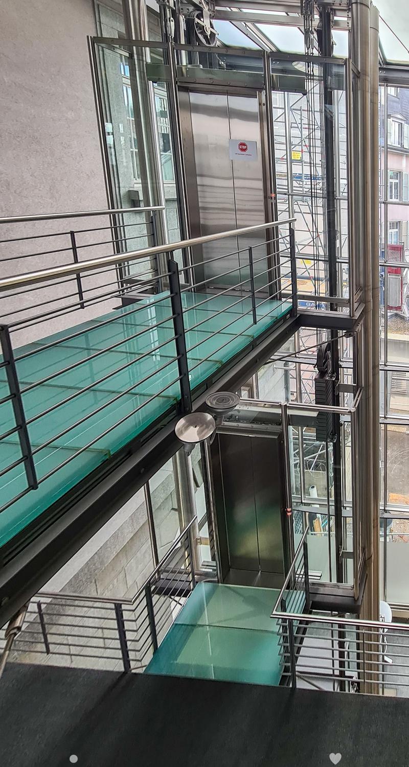 glass-paneled balcony, open glass-paneled railing, staircases on two sides