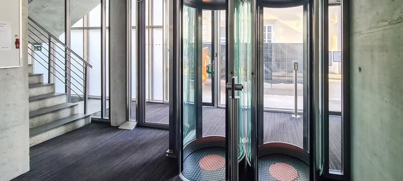entryway with large rotating doors and stairs leading to higher level
