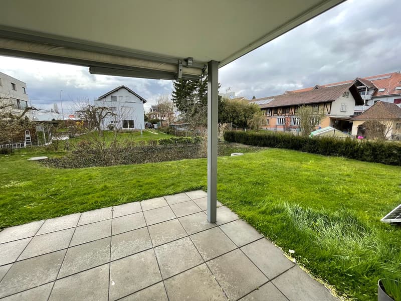 tiled patio, green lawn, hedges, solar panel, metal pole