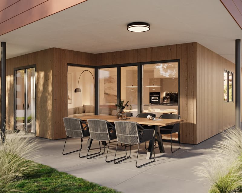Dining area with wooden table and chairs, large glass windows, wooden wall, ceiling lamp
