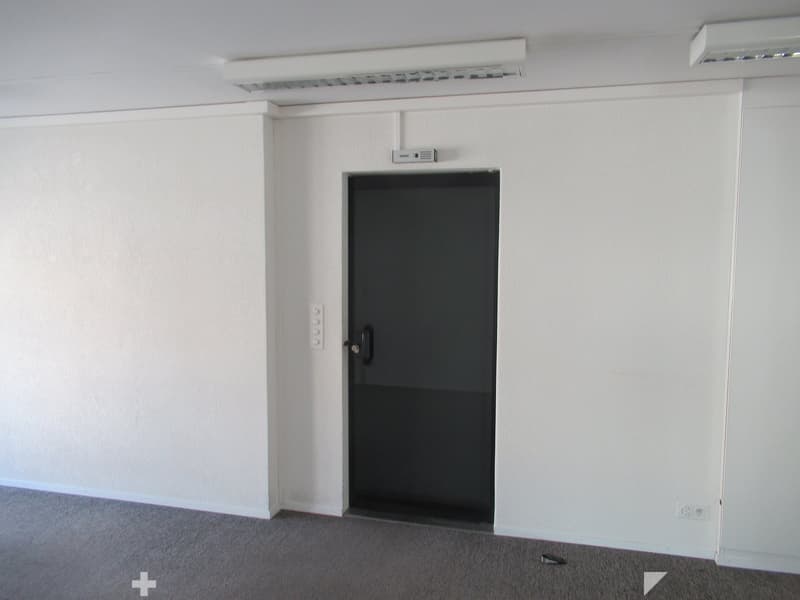empty room with a door, white walls, gray floor, closed door
