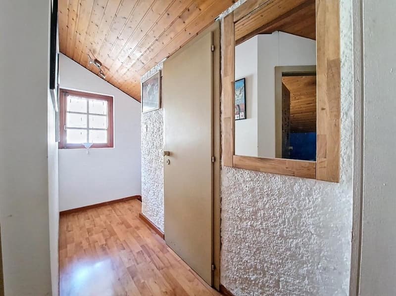wooden ceiling, wooden floor, white walls, small window, mirror, picture frame