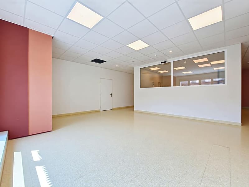 Empty room with white walls, beige floor, white door, glass windows, square ceiling lights