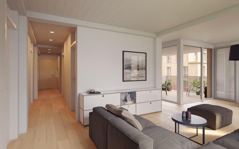 large room, wooden floor, modern white cabinets, gray couch, round table, framed picture, large windows, balcony with plants