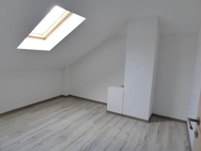 empty attic room with slanted ceiling, white walls, wooden floor, skylight