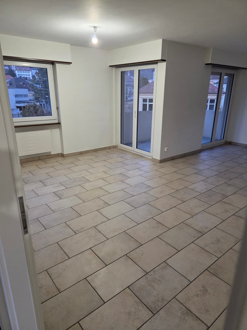 empty room, beige tiles, white walls, sliding doors leading to balcony, white sliding doors