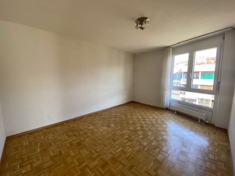 empty room with hardwood floors and large windows providing a view