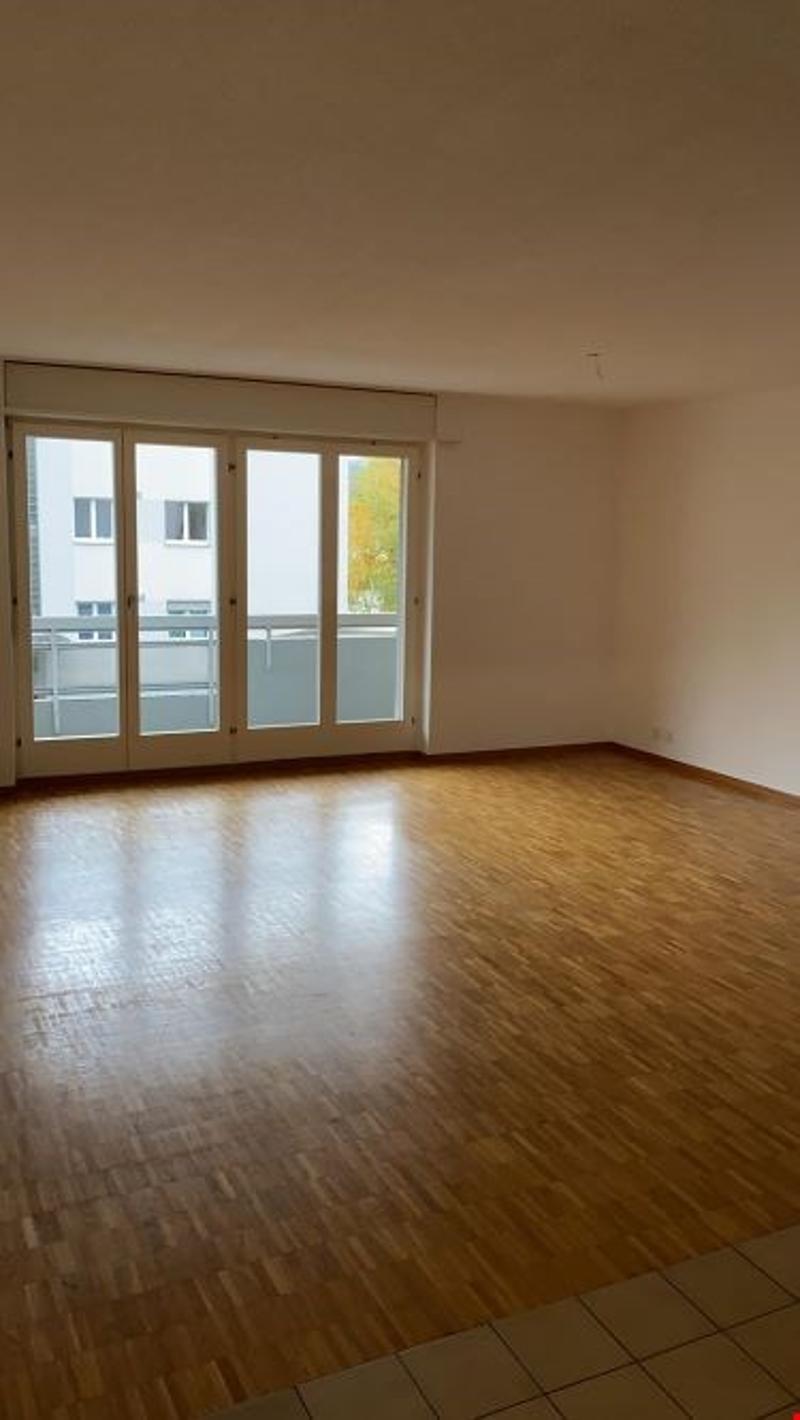 empty room, wooden floor, large glass doors to balcony, white walls