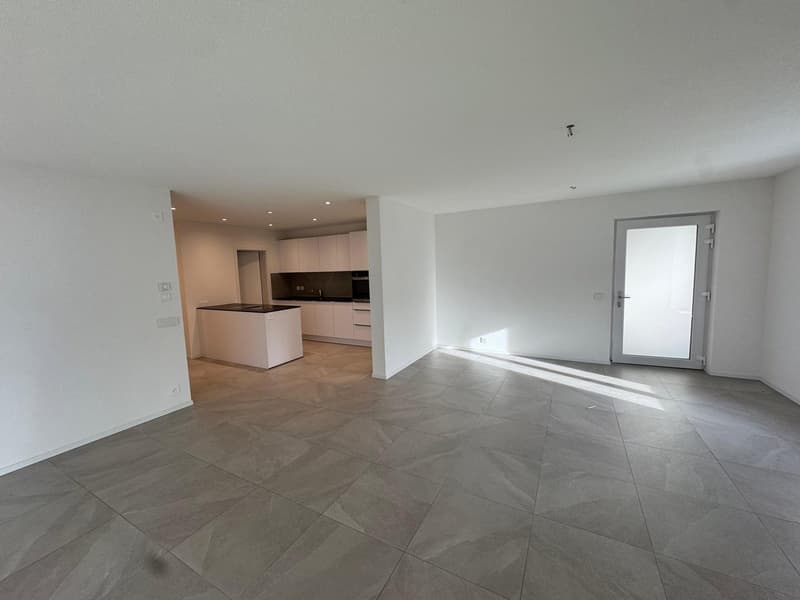 empty room, tiled floor, white walls, kitchen area with countertop and appliances, entrance door