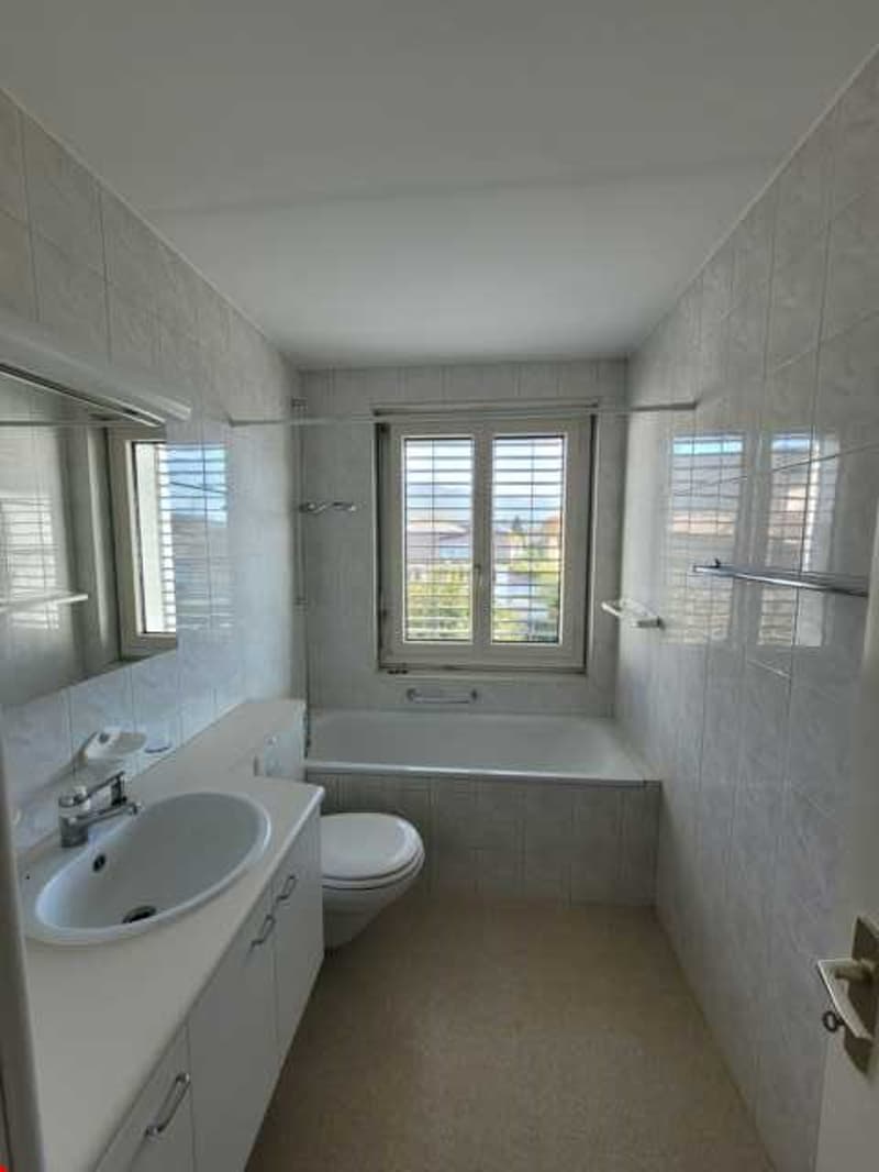 Bathroom with a bathtub, sink, mirror, and toilet.