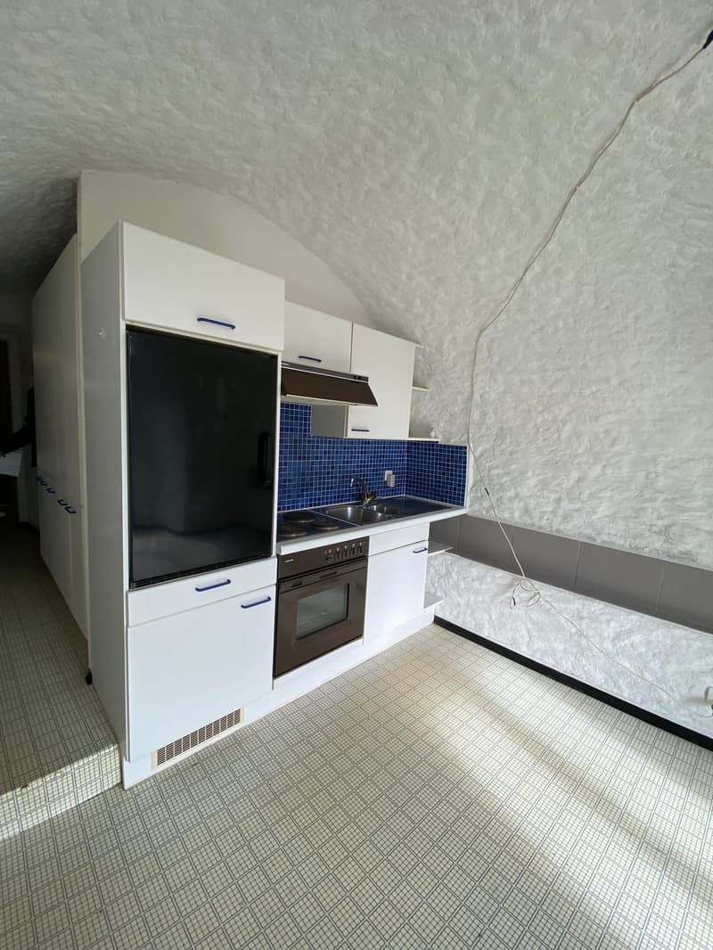 modern kitchen with white cabinets, blue tiles, black refrigerator, oven, sink, and countertop