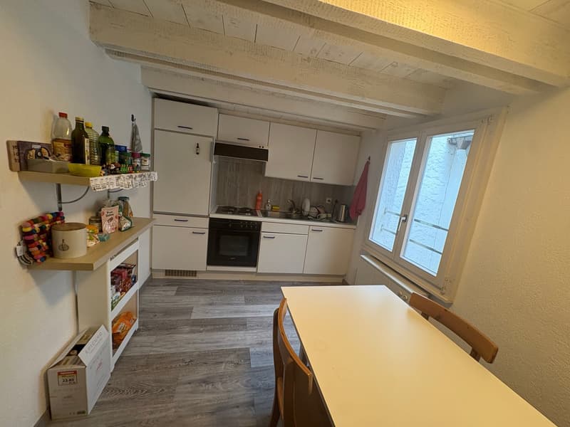kitchen with dining area, white cabinets, wooden floor, window, gas stove, sink, refrigerator, shelves with various items