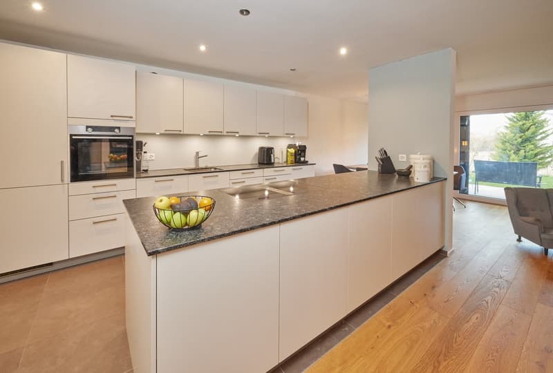 White cabinets, granite countertop, stainless steel appliances, breakfast bar, dining area, large windows