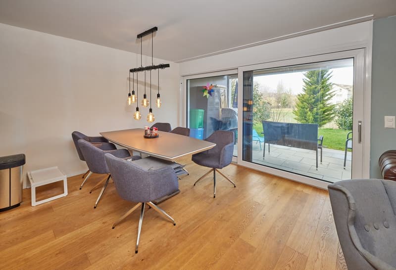 Dining room with large sliding doors to the terrace, large dining table, chairs, floor lamp