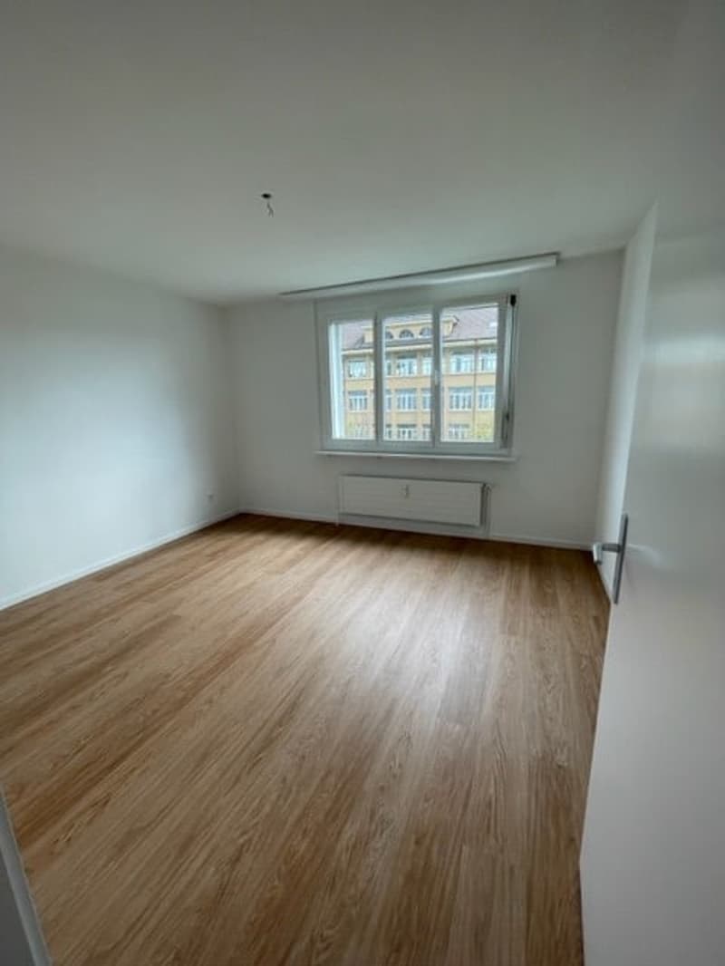 empty room, wooden floor, white walls, large window, white door