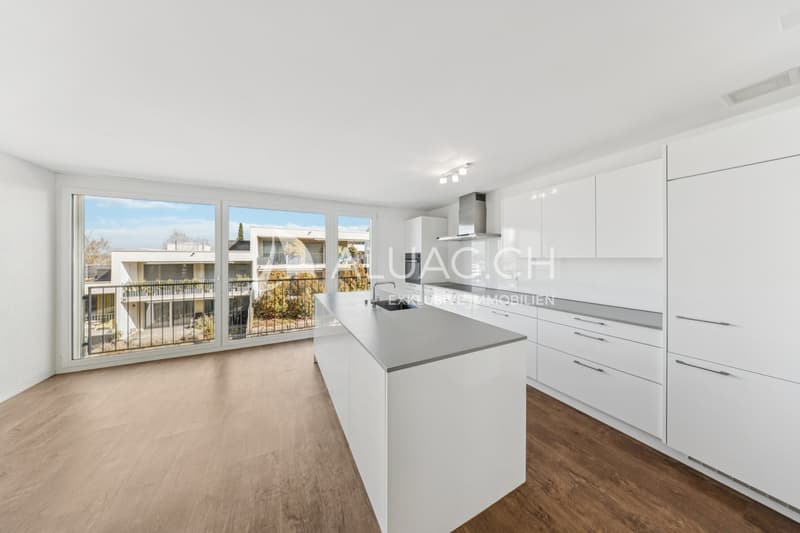 Das Herzstück der Wohnung bildet die moderne Küche mit Kochinsel sowie der offene Wohn- und Essbereich