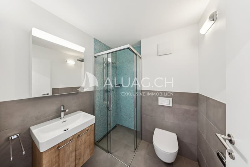 Stilvolles Badezimmer mit grauen Bodenplatten und bodenebener Dusche
