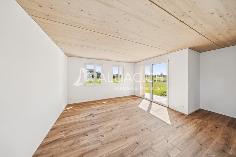 Lichtdurchflutetes Wohnzimmer mit offener Gestaltung und Parkettboden und direktem Zugang zur Terrasse