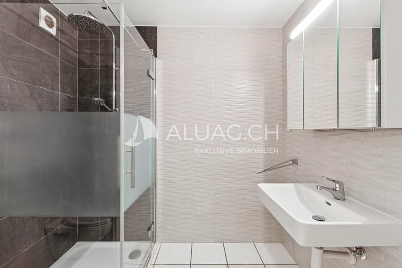Zeitlos gestaltetes Badezimmer mit bodenebener Dusche und pflegeleichtem Ausbaustandard