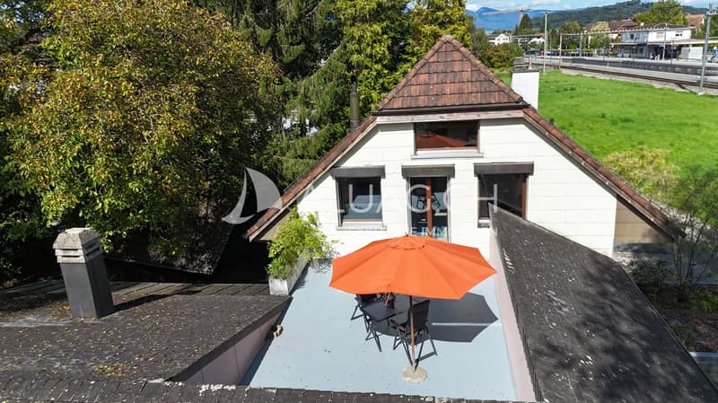 Von hier aus betritt man eine ruhige Terrasse, idyllisch umgeben von Bäumen
