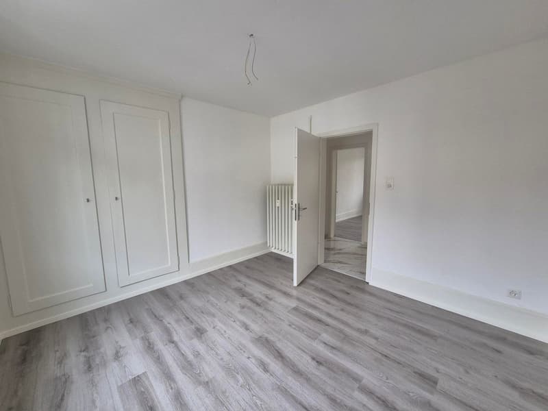 empty room with white walls, wooden floor, large double closet, open door