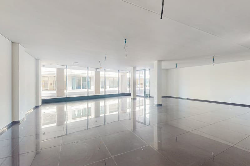 empty room with tiled floors, white walls, floor-to-ceiling windows with black frames