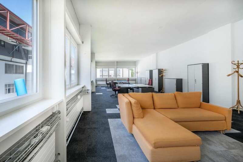 large living room, large windows, beige sofa, table, chairs, office desk, radiators