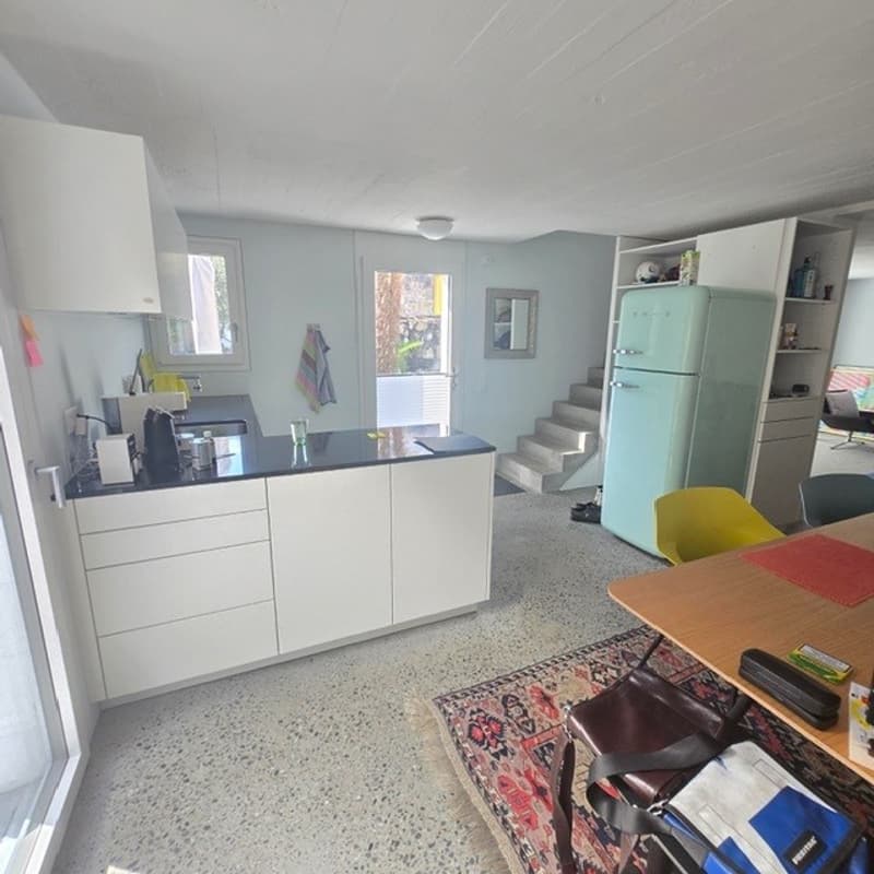 Kitchen, white cabinets, granite countertops, refrigerator, wooden table, chairs, rug, stairs