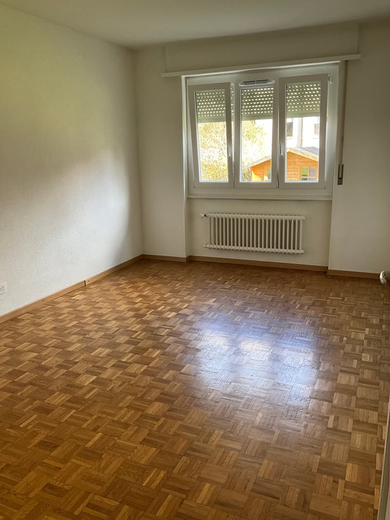 empty room, wooden parquet floor, white walls, large window, white radiator