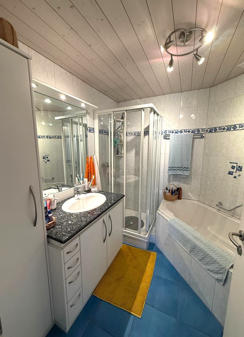 bathroom with shower, bathtub, sink, cabinets, mirror, blue tiles