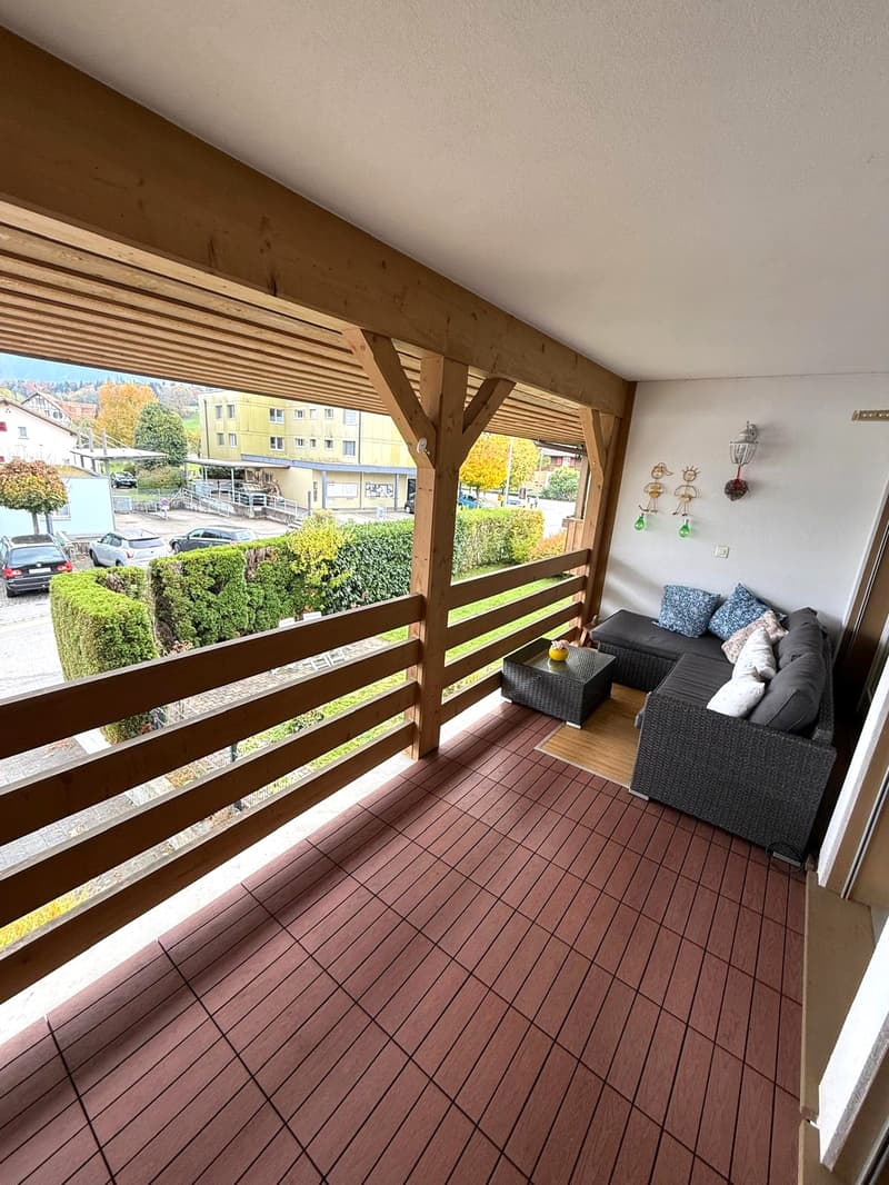 terraced living room, wooden decking, comfortable seating area, wooden railings, outdoor seating furniture, wooden beams, garden view, decorative wall elements