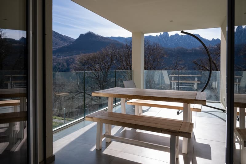 wooden table and benches, glass railing, mountain view