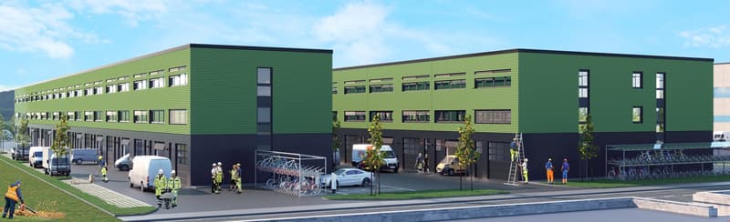 A large multi-story commercial building with a green exterior and numerous windows. There are several vehicles parked in the front, as well as people walking around the building. The building appears to be a modern industrial or office complex.